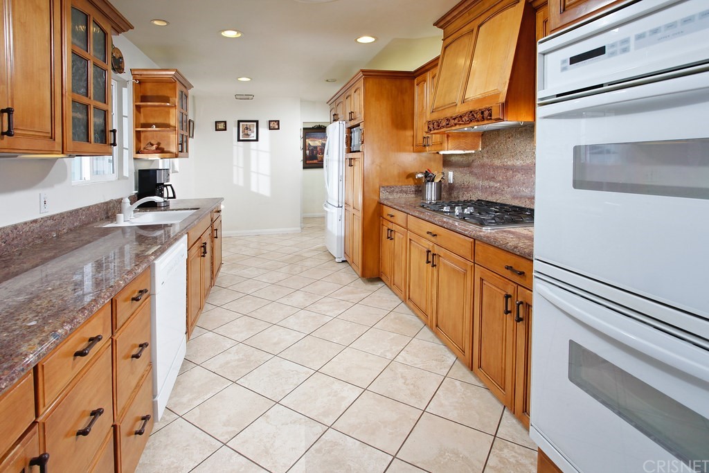 a kitchen with stainless steel appliances granite countertop a stove a sink and a refrigerator