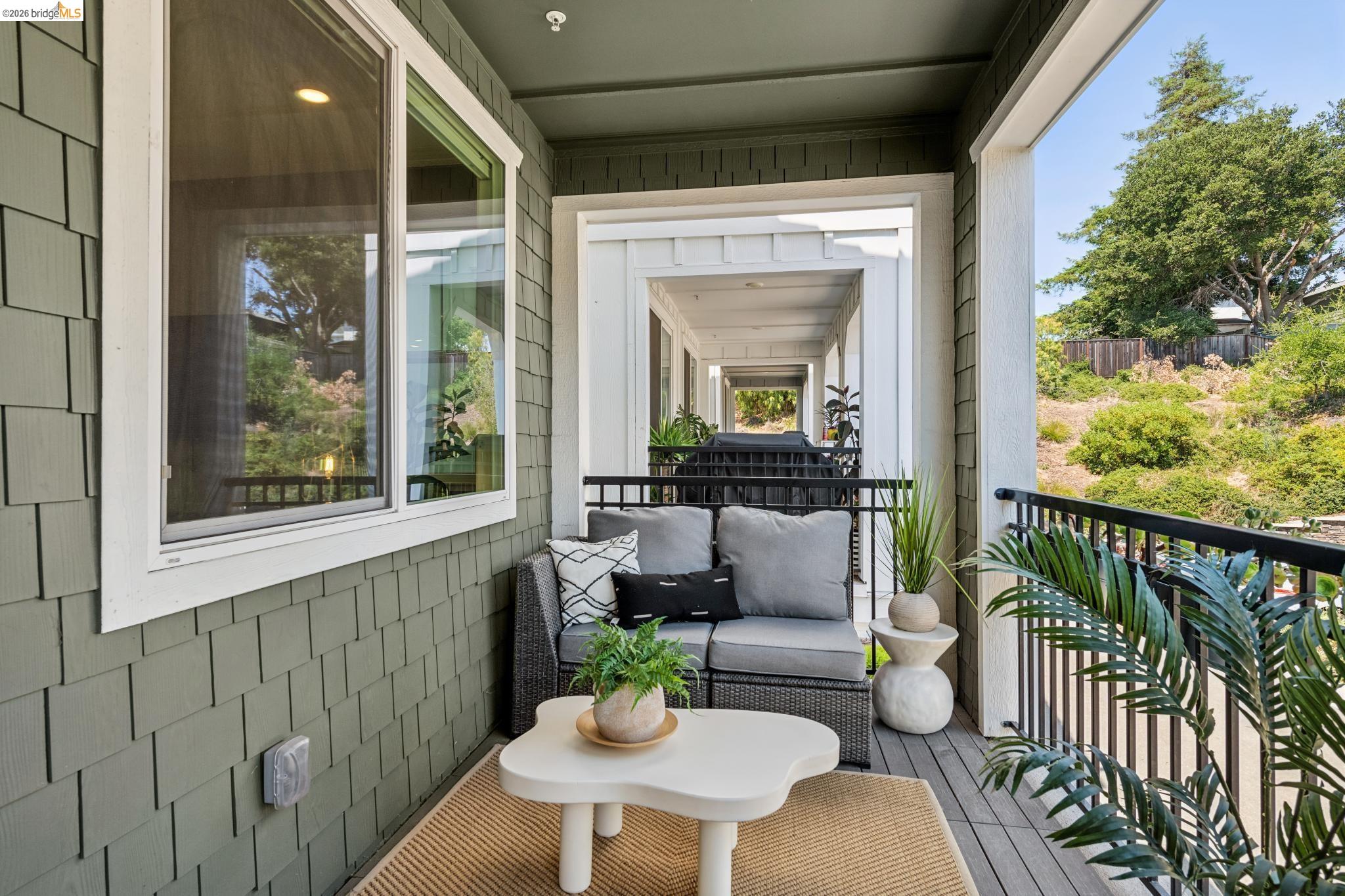 24157 Amaranth Loop Hayward, CA 94541 - Photo 51 of 63 Shingle siding exterior featuring a covered balcony with composite decking, black metal railings, and a window with white trim