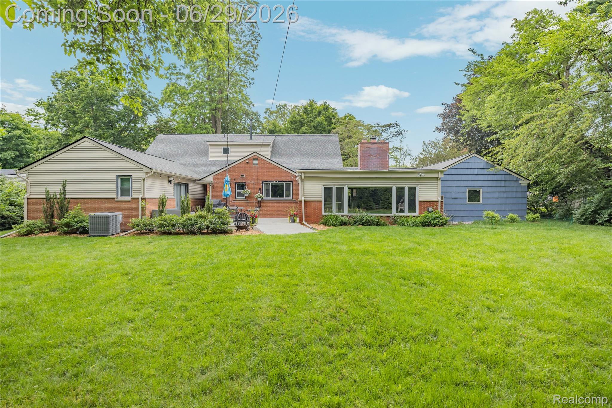 6085 Worlington Road Bloomfield Hills, MI 48301 - Photo 62 of 75 Expansive rear yard featuring a large green lawn, mature perimeter trees, and a concrete patio
