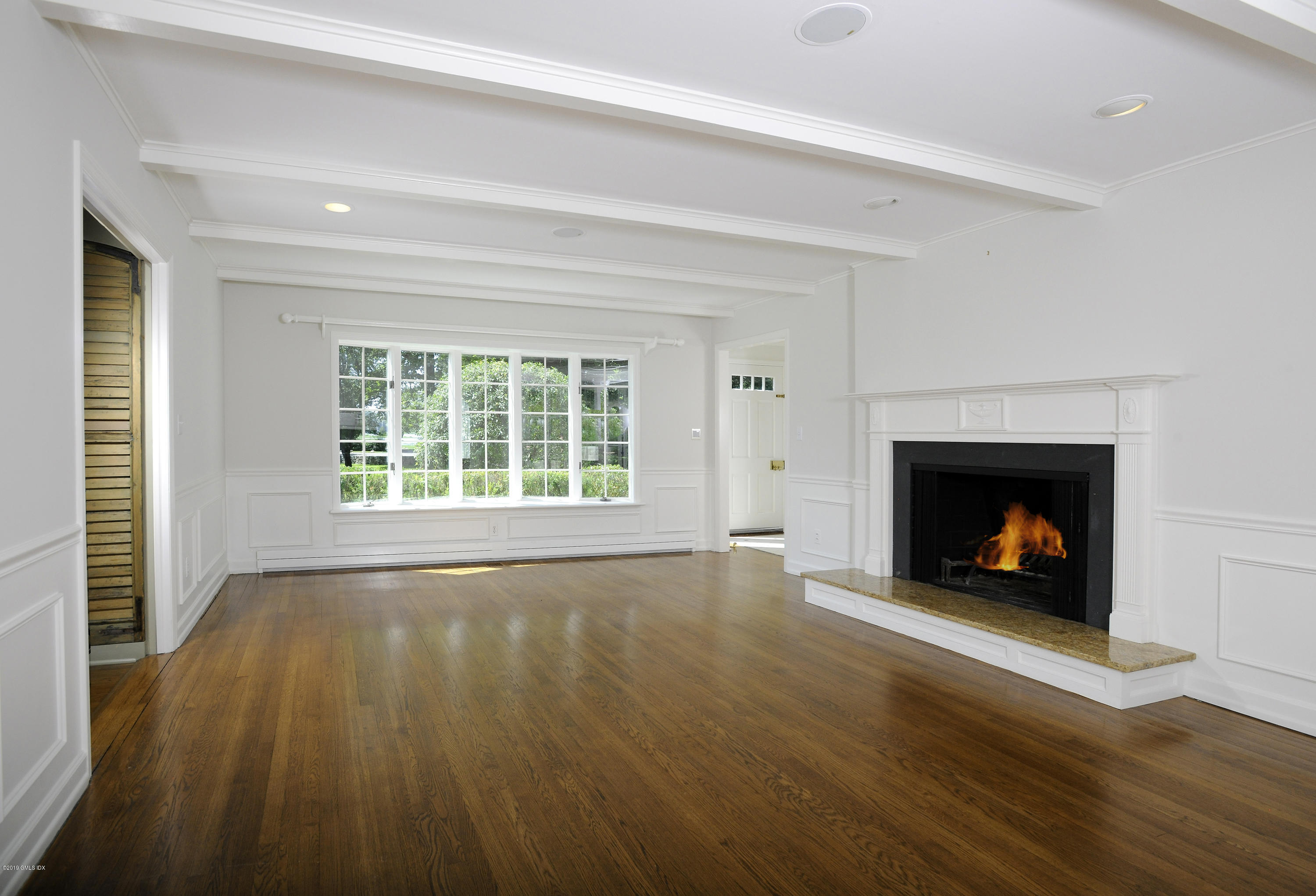 177 Indian Head Road Riverside, CT 06878 - Photo 6 of 24 a view of an empty room with wooden floor fireplace and a window