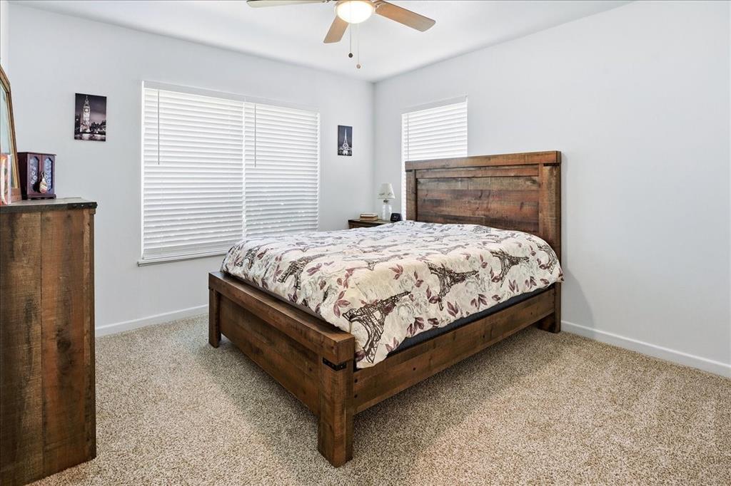 12657 Alma Street Tyler, TX 75704 - Photo 21 of 36 a bedroom with a bed and a chandelier fan
