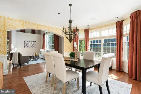a dining room with furniture a chandelier and wooden floor