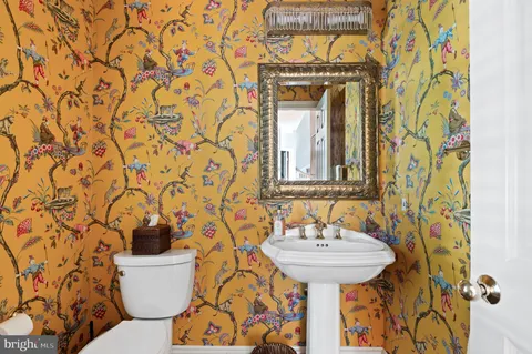 a bathroom with a toilet sink and mirror