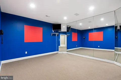an empty room with windows and ceiling fan