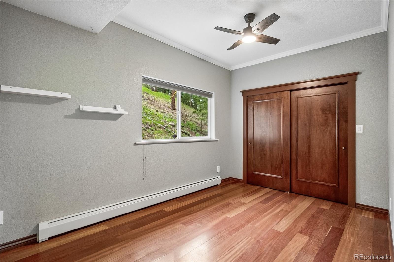 6747 South Brook Forest Road Evergreen, CO 80439 - Photo 27 of 49 a view of empty room with wooden floor and fan