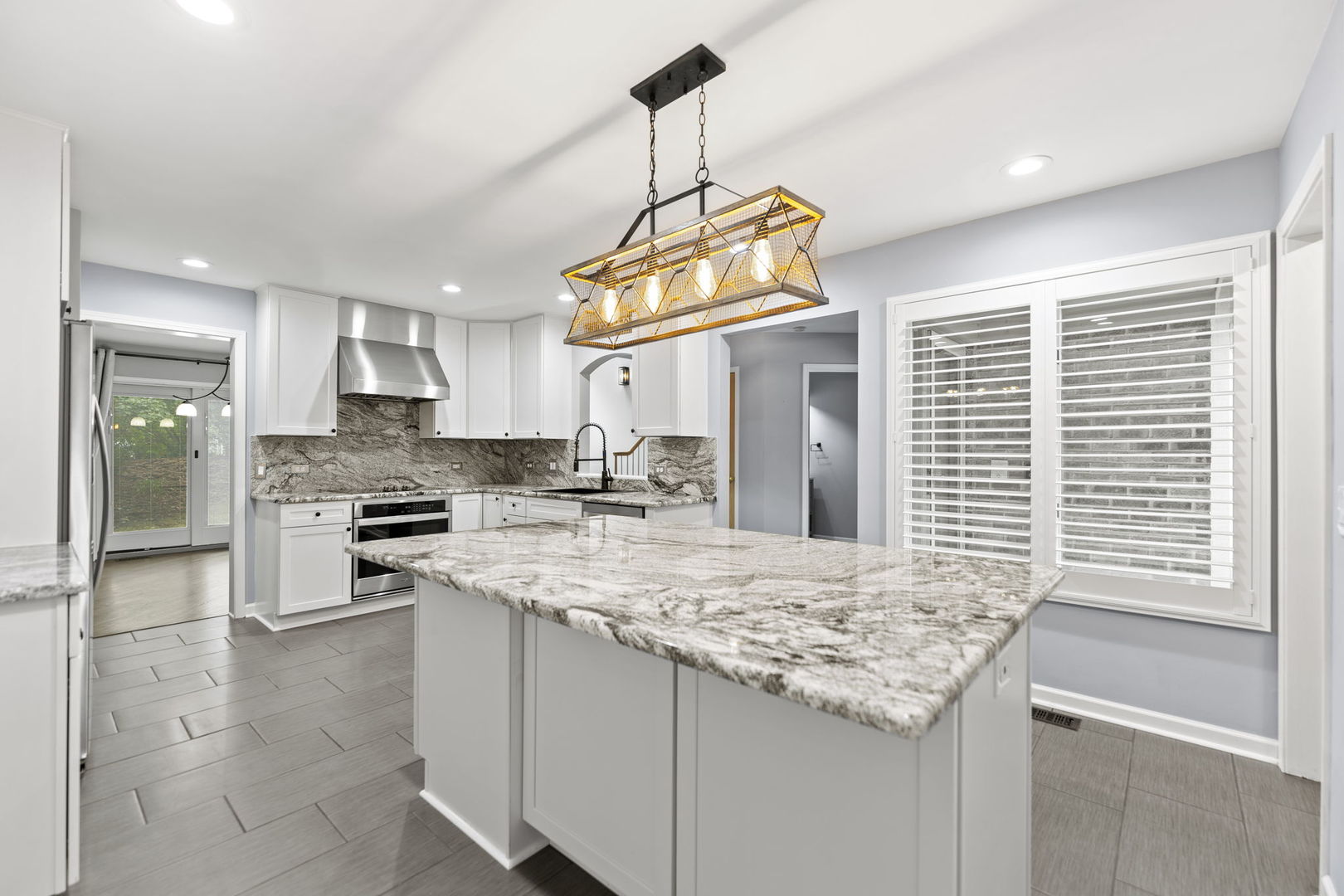 5509 Aspen Avenue Downers Grove, IL 60515 - Photo 6 of 38 a kitchen with stainless steel appliances granite countertop a sink a stove a refrigerator cabinets and living room view