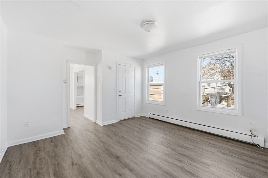 5 Floyd Street Lowell, MA 01852 - Photo 11 of 35 an empty room with wooden floor and windows