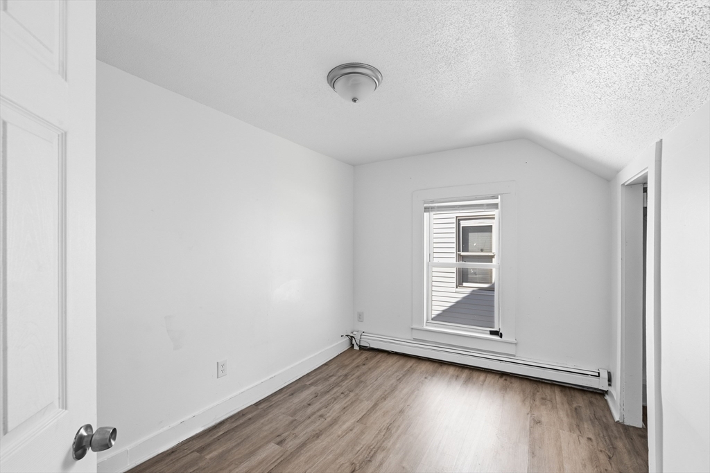 5 Floyd Street Lowell, MA 01852 - Photo 12 of 35 an empty room with wooden floor and windows