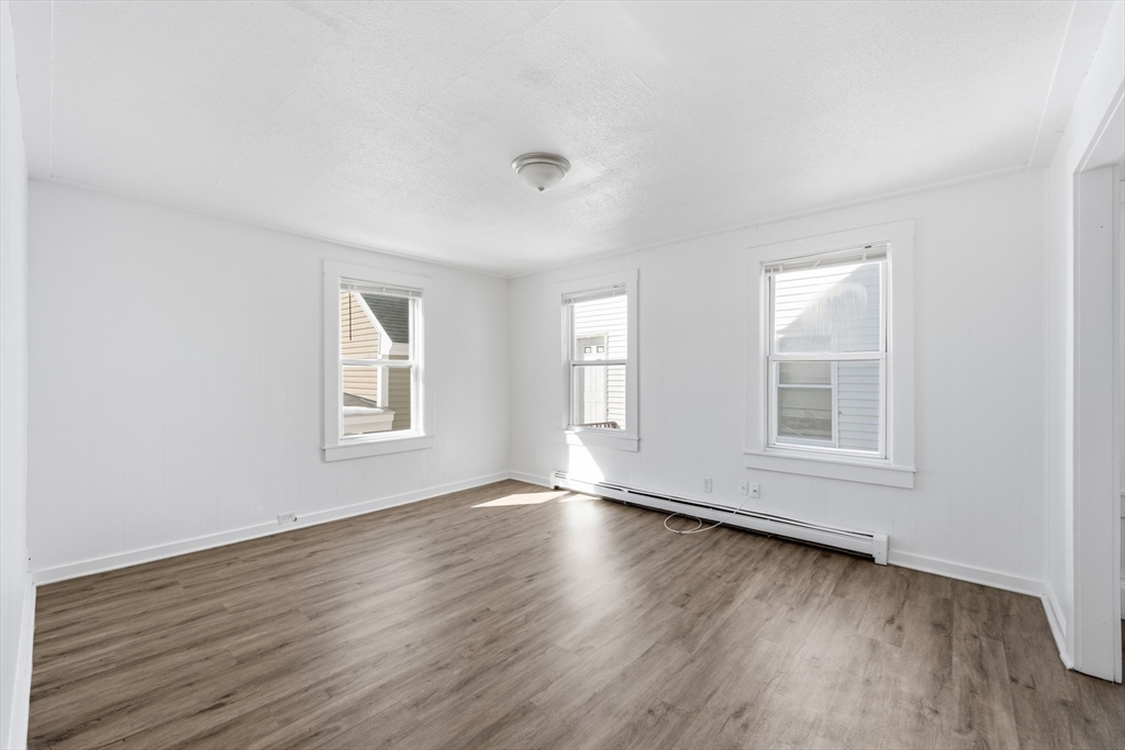 5 Floyd Street Lowell, MA 01852 - Photo 24 of 35 an empty room with wooden floor and windows
