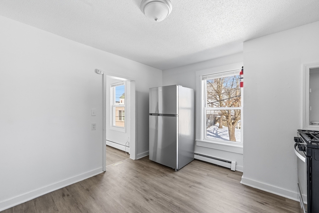 5 Floyd Street Lowell, MA 01852 - Photo 5 of 35 an empty room with wooden floor cabinet and windows