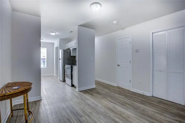 a view of a hallway with wooden floor and chair