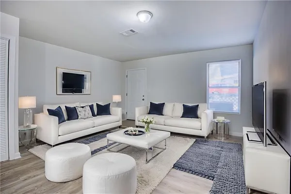 a living room with furniture a flat screen tv and a table