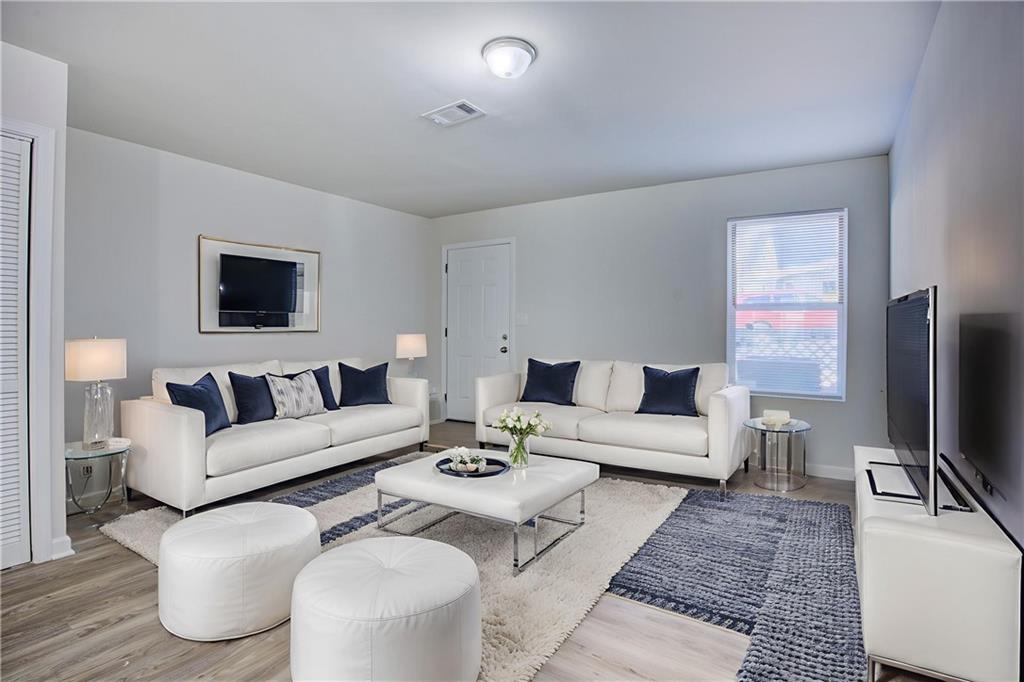 2340 Beaver Ruin Road, Unit UN15 Norcross, GA 30071 - Photo 2 of 30 a living room with furniture a flat screen tv and a table