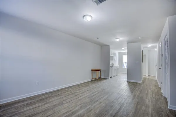 a view of empty room with wooden floor