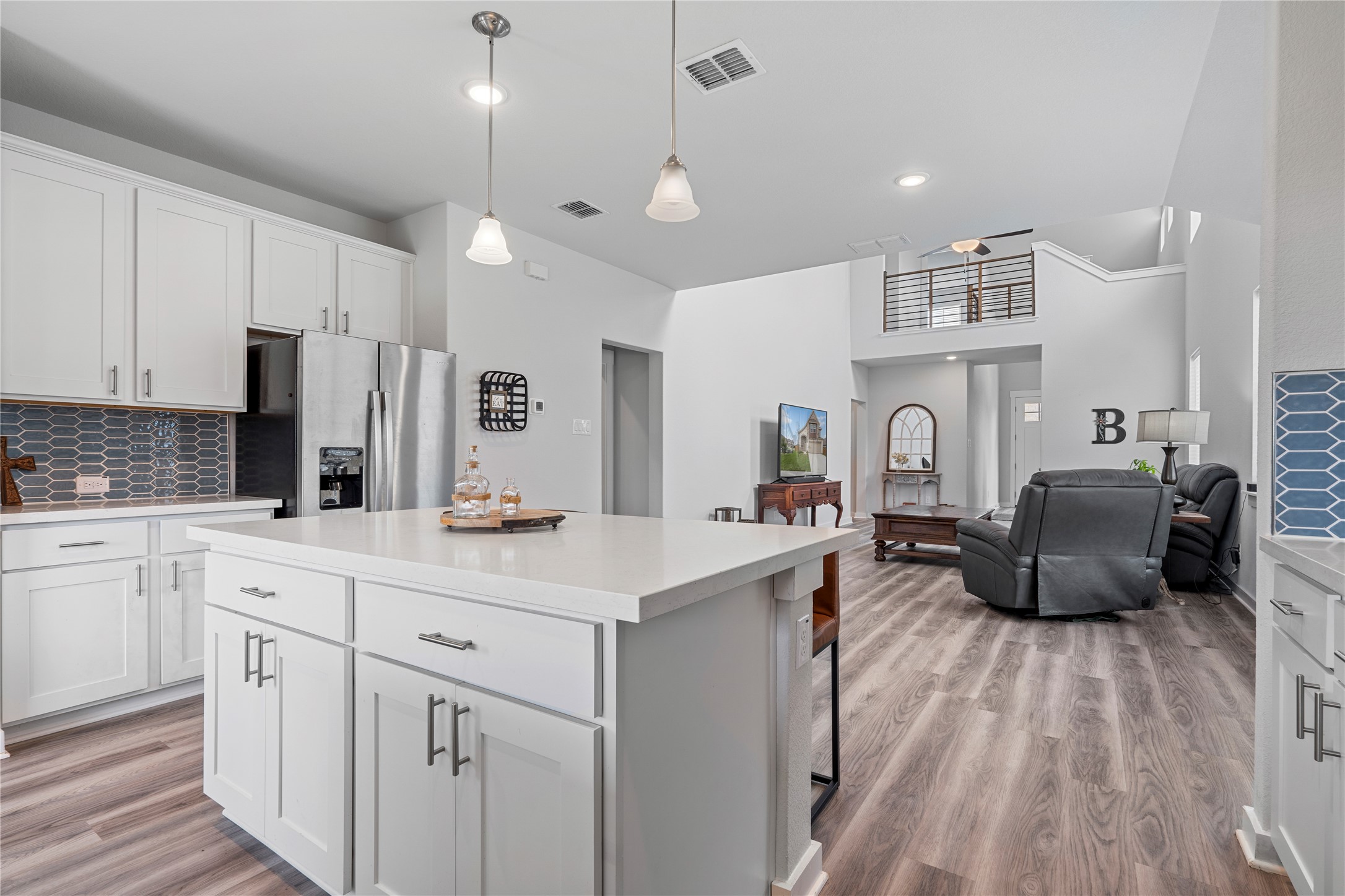 660 Pheasant Hill Lane Georgetown, TX 78628 - Photo 13 of 38 a kitchen with stainless steel appliances kitchen island granite countertop a sink dishwasher a refrigerator and white cabinets with wooden floor