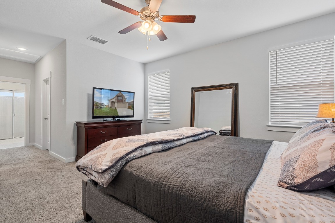 660 Pheasant Hill Lane Georgetown, TX 78628 - Photo 15 of 38 a bedroom with a bed and a chandelier