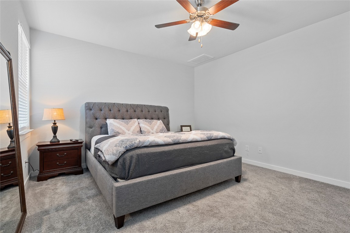 660 Pheasant Hill Lane Georgetown, TX 78628 - Photo 16 of 38 a spacious bedroom with a bed and a chandelier
