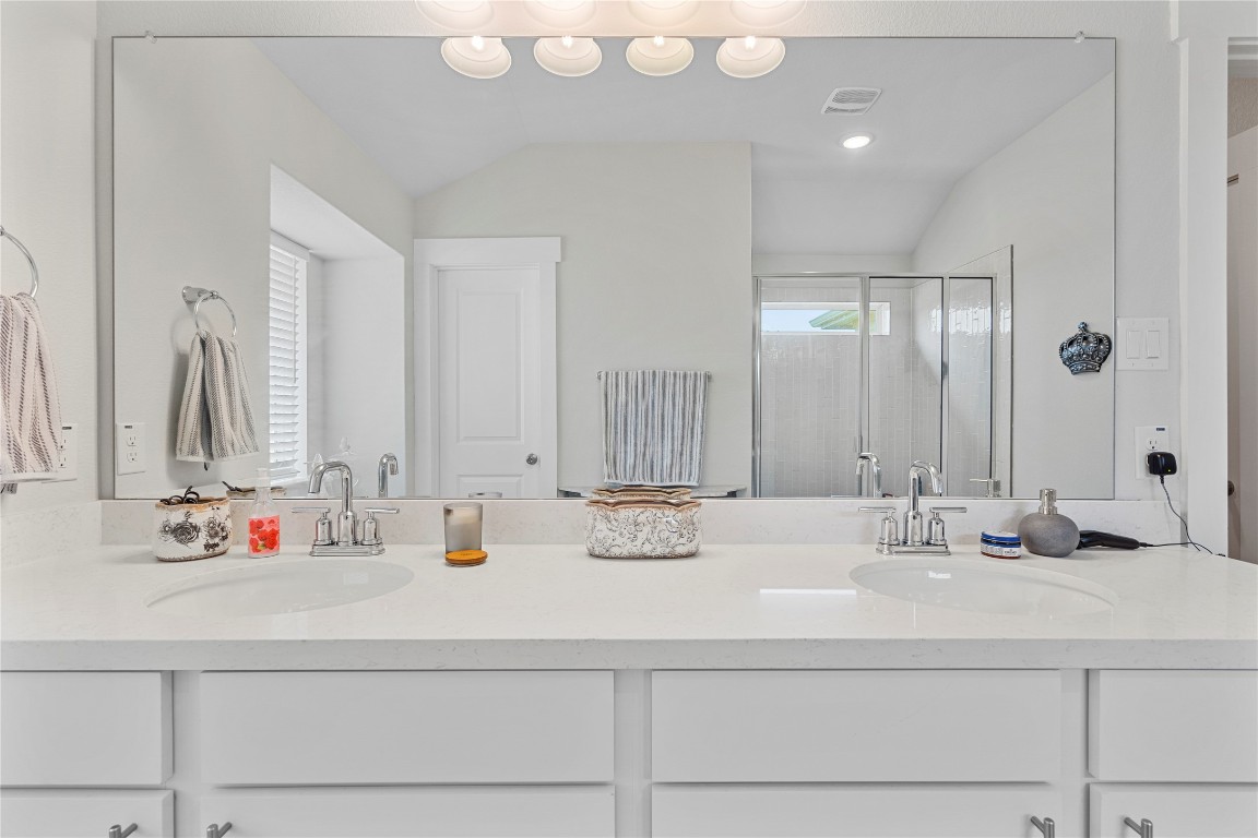 660 Pheasant Hill Lane Georgetown, TX 78628 - Photo 19 of 38 a bathroom with double vanity sinks and a mirror