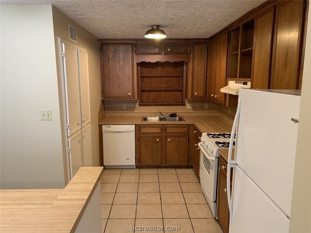 a kitchen with a stove cabinets and a refrigerator