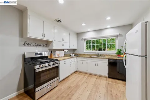 a kitchen with a stove a sink and a window