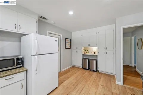 a kitchen with granite countertop white cabinets and stainless steel appliances