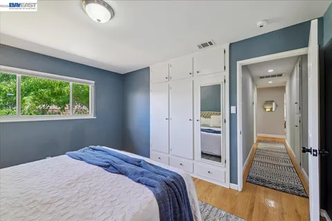 a bedroom with a bed and wooden floor