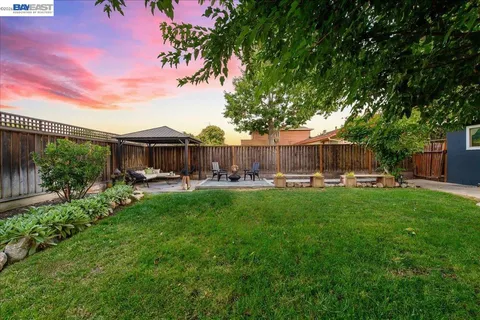 a front view of a house with garden and a bench