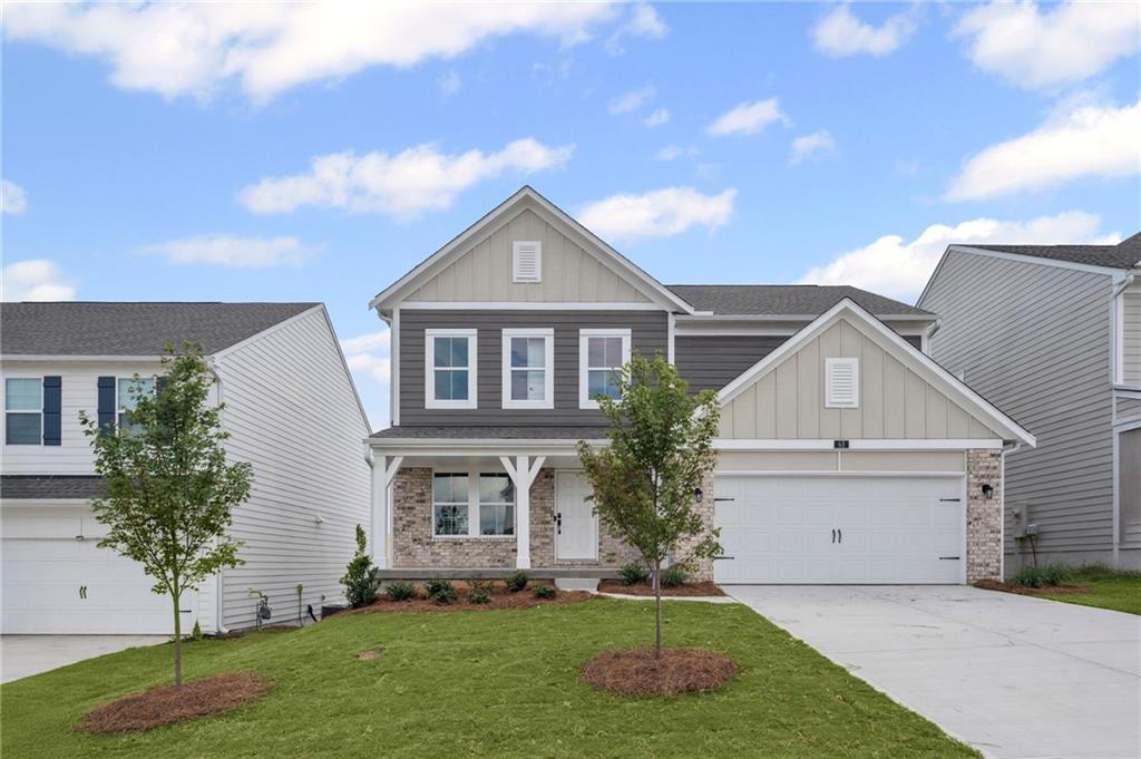 61 Okeechobee Way Hoschton, GA 30548 - Photo 1 of 1 a front view of a house with a garden and plants