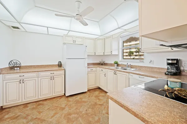 a kitchen with white cabinets and white appliances