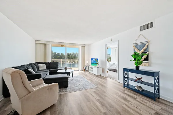 a living room with furniture lamp and a potted plant