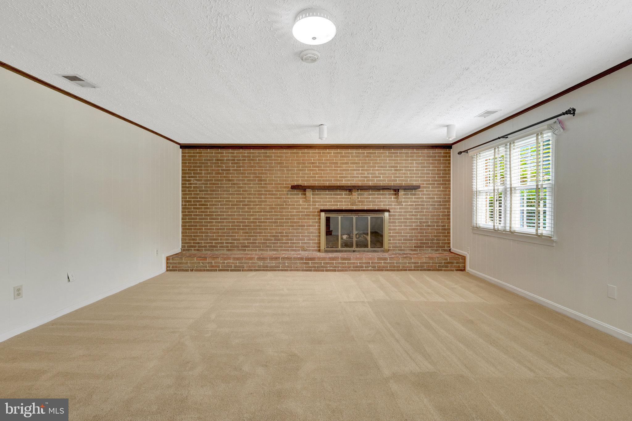 615 Kearney Court Southwest Vienna, VA 22180 - Photo 14 of 53 an empty room with a fireplace and windows