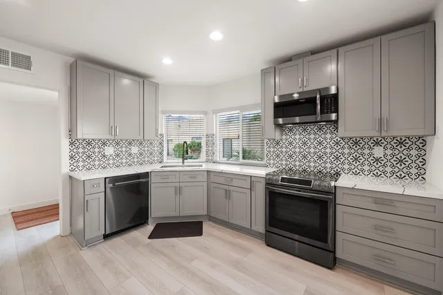 a kitchen with granite countertop cabinets stainless steel appliances and sink