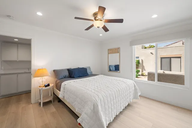 a bedroom with a bed and a large window