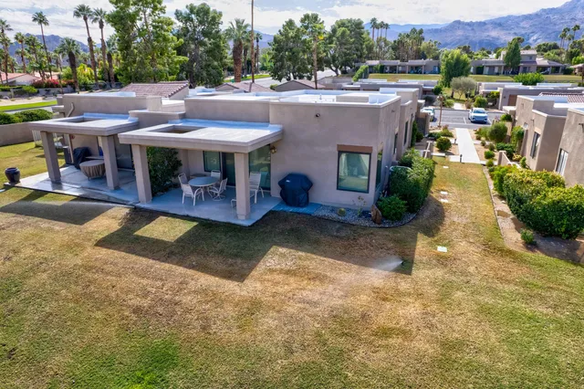 an aerial view of a house with swimming pool and a yard