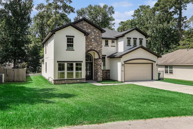 a front view of a house with a yard and garage