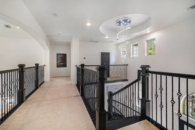 a view of a hallway with wooden floor and windows
