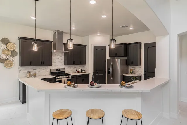 a kitchen with stainless steel appliances a refrigerator sink and microwave