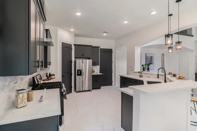 a kitchen with kitchen island a sink appliances and cabinets