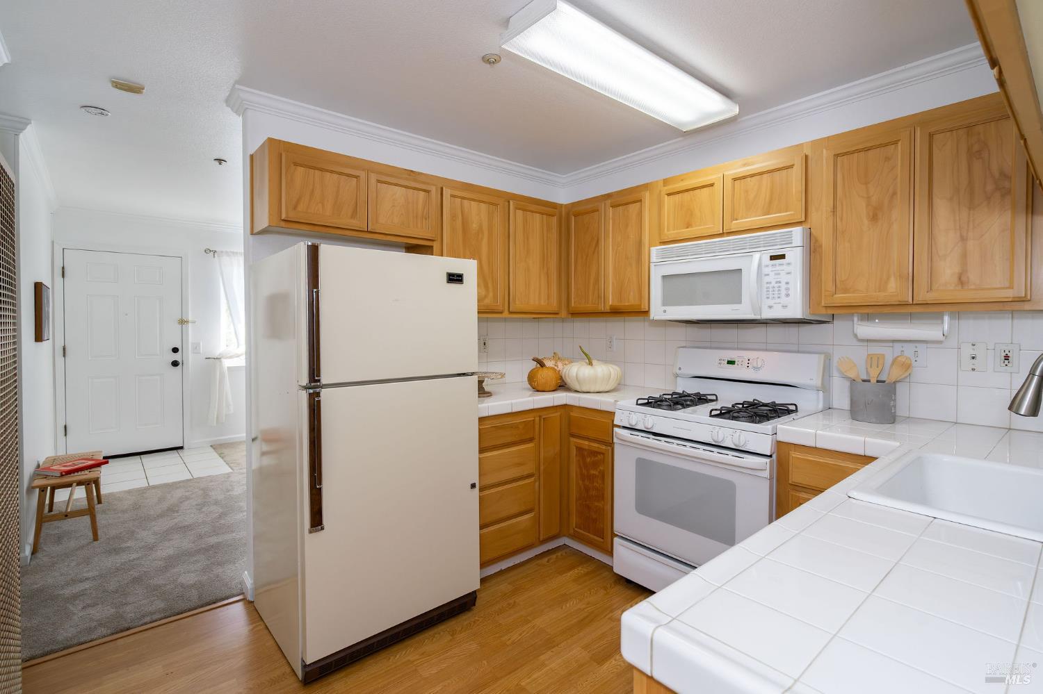 1501 La Esplanada Place, Unit 326 Santa Rosa, CA 95404 - Photo 6 of 10 a kitchen with a refrigerator a stove top oven a sink and cabinets
