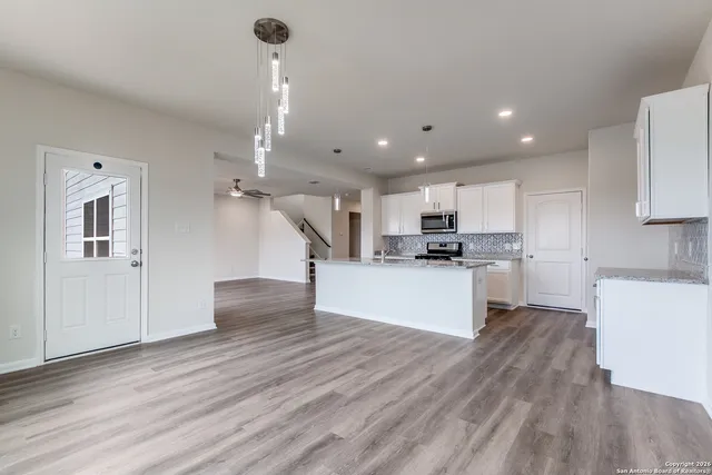 a kitchen with kitchen island white cabinets and stainless steel appliances