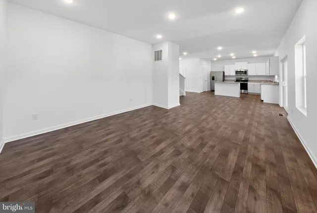 a view of a kitchen with a refrigerator kitchen counter top and wooden floor