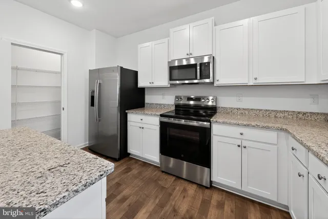 a kitchen with stainless steel appliances white cabinets and a refrigerator