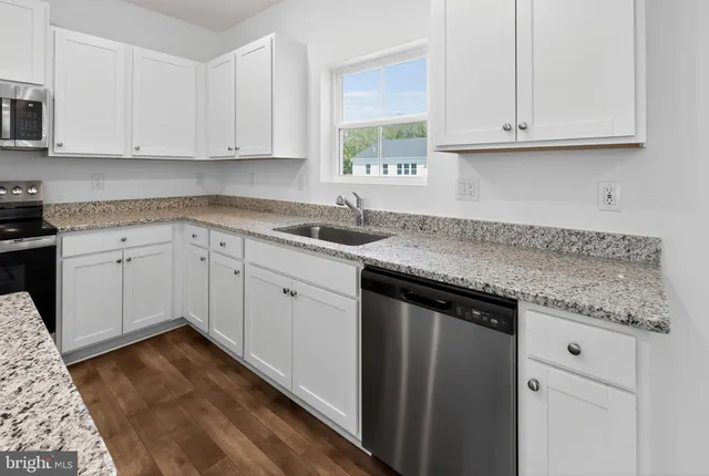 a kitchen with granite countertop cabinets sink and window