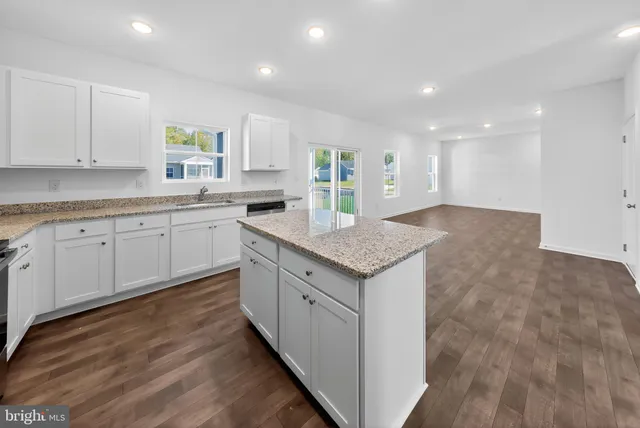 a kitchen with granite countertop sink stove and cabinets