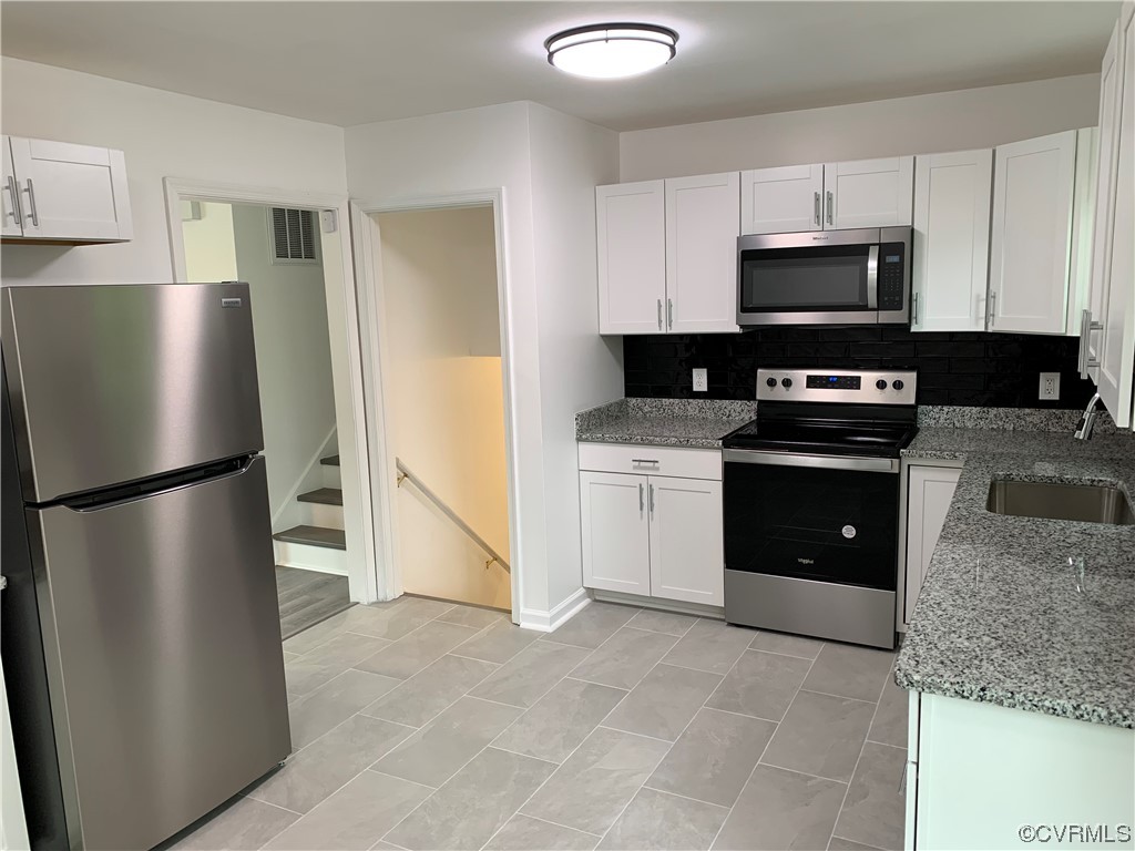 1616 Westbrook Road Hopewell, VA 23860 - Photo 5 of 24 a kitchen with stainless steel appliances granite countertop a refrigerator a stove a sink and white cabinets