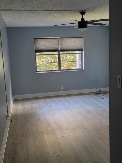 9440 Southwest 8th Street, Unit 417 Boca Raton, FL 33428 - Photo 11 of 21 an empty room with a window and a ceiling fan