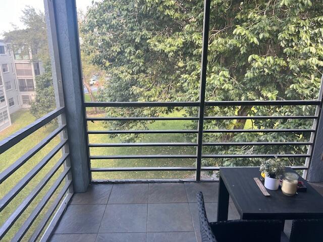 9440 Southwest 8th Street, Unit 417 Boca Raton, FL 33428 - Photo 18 of 21 a view of a balcony with chairs and wooden fence