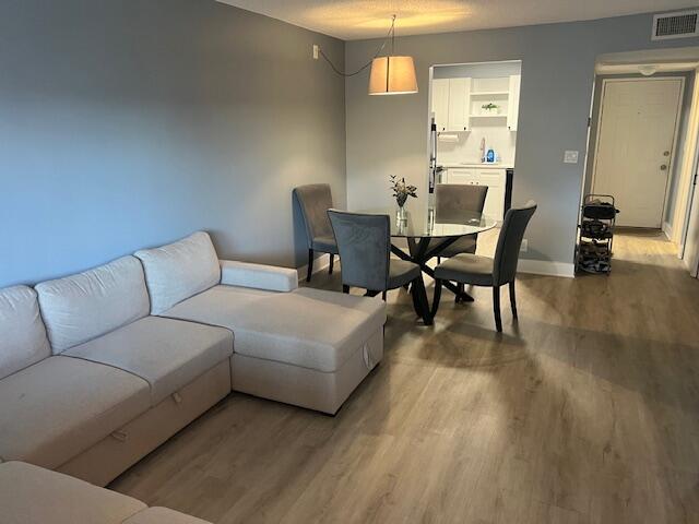 9440 Southwest 8th Street, Unit 417 Boca Raton, FL 33428 - Photo 4 of 21 a living room with furniture and a dining table with wooden floor