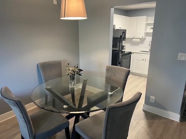 9440 Southwest 8th Street, Unit 417 Boca Raton, FL 33428 - Photo 5 of 21 a view of a dining room with furniture and wooden floor