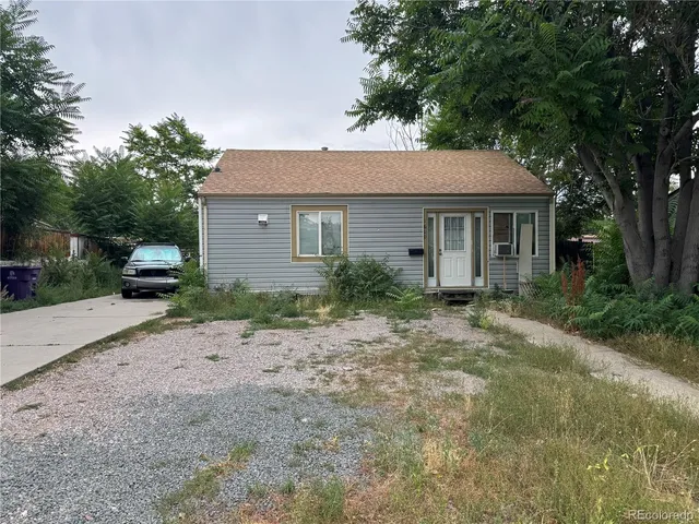 a view of house with yard and car parked